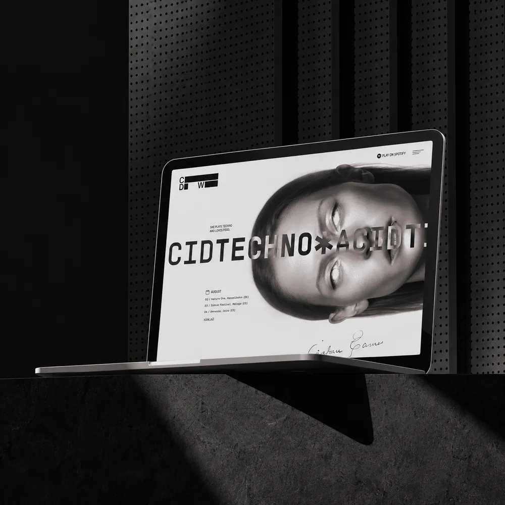 Charlotte de Witte website on a laptop in a dark room, a face lying sideways across the screen