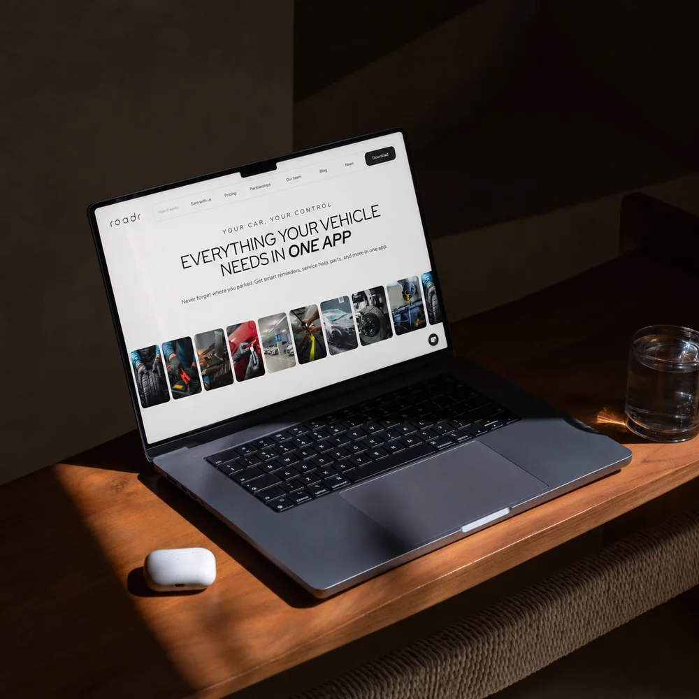 Roadr website on a laptop on a wooden desk: “Everything your vehicle needs in one app”